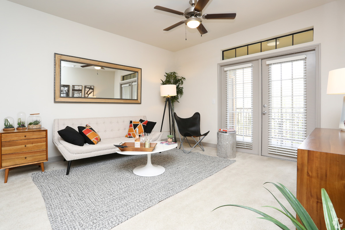 Model living room with plush carpeting, ceiling fan, cable ready, and access to patio/balcony door